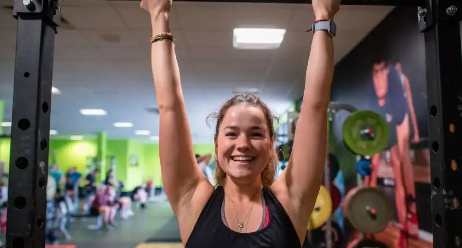 A student exercising in a gym on campus.