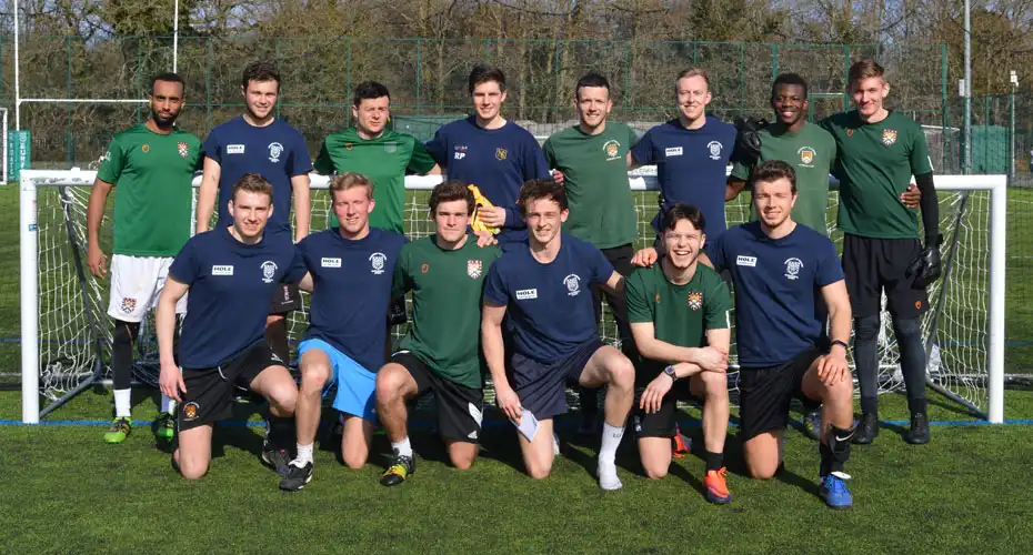 University of Exeter student football players stood taking a team photo.